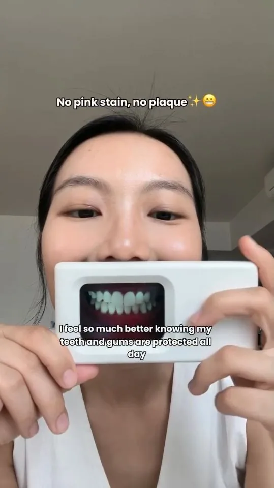 Person holding a plaque-light viewer displaying teeth, image 04