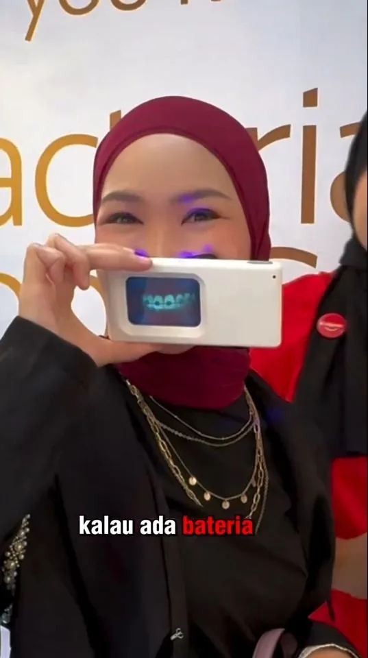 Person holding a plaque-light viewer displaying teeth, image 05