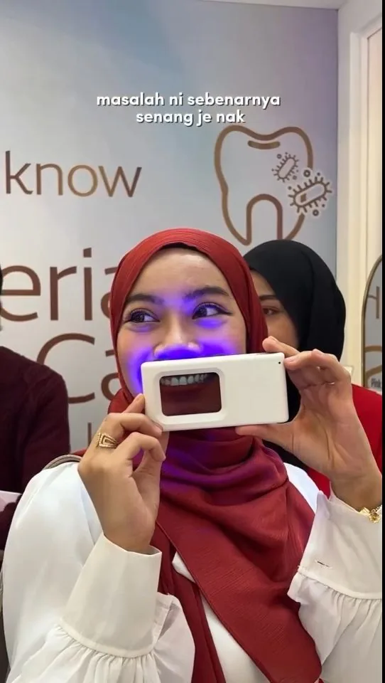 Person holding a plaque-light viewer displaying teeth, image 08