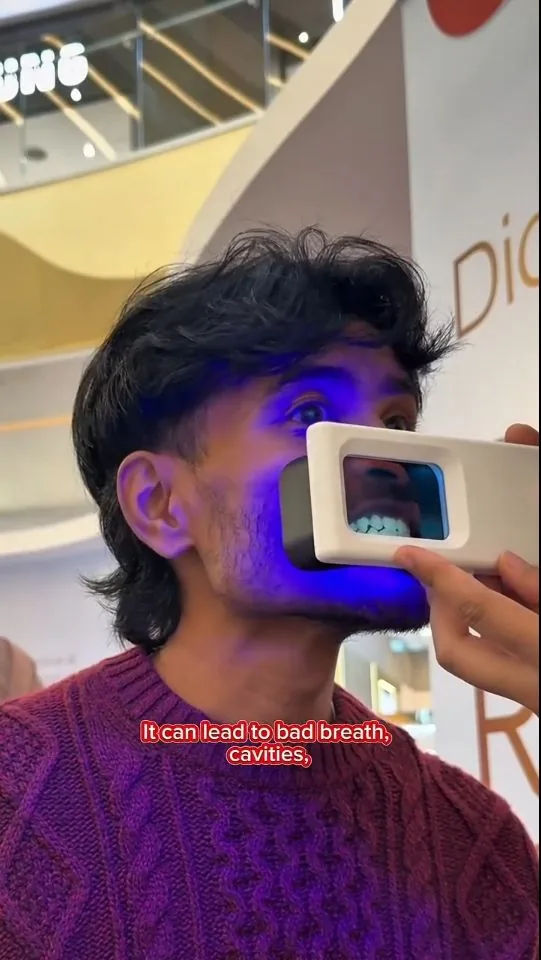 Person under violet illumination during a plaque-light demonstration, image 14