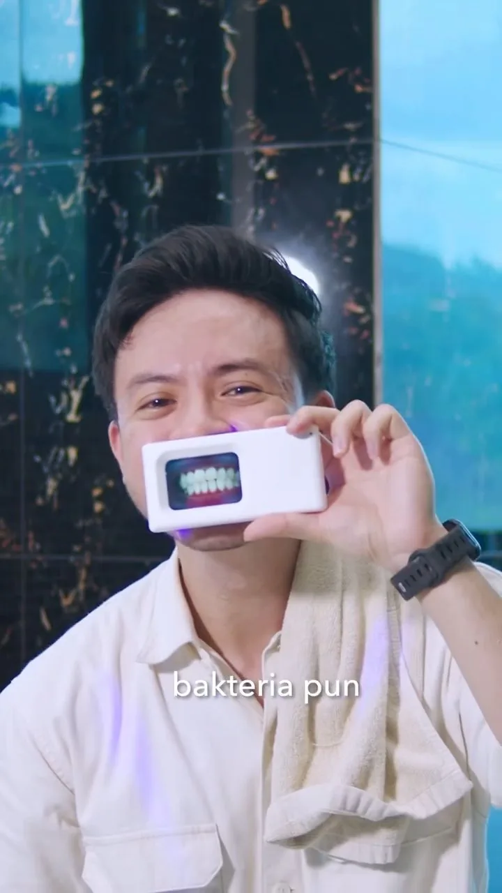 Person holding a plaque-light viewer displaying teeth, image 32