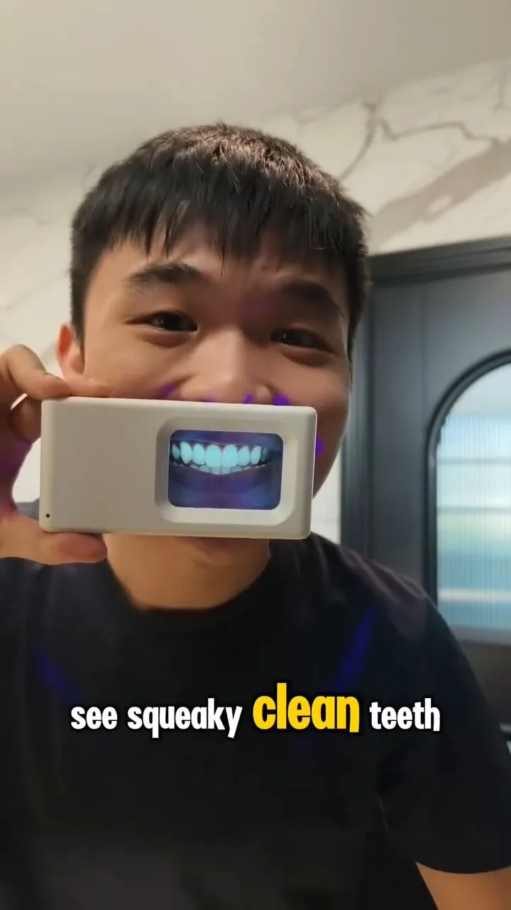 Person holding a plaque-light viewer displaying teeth, image 34