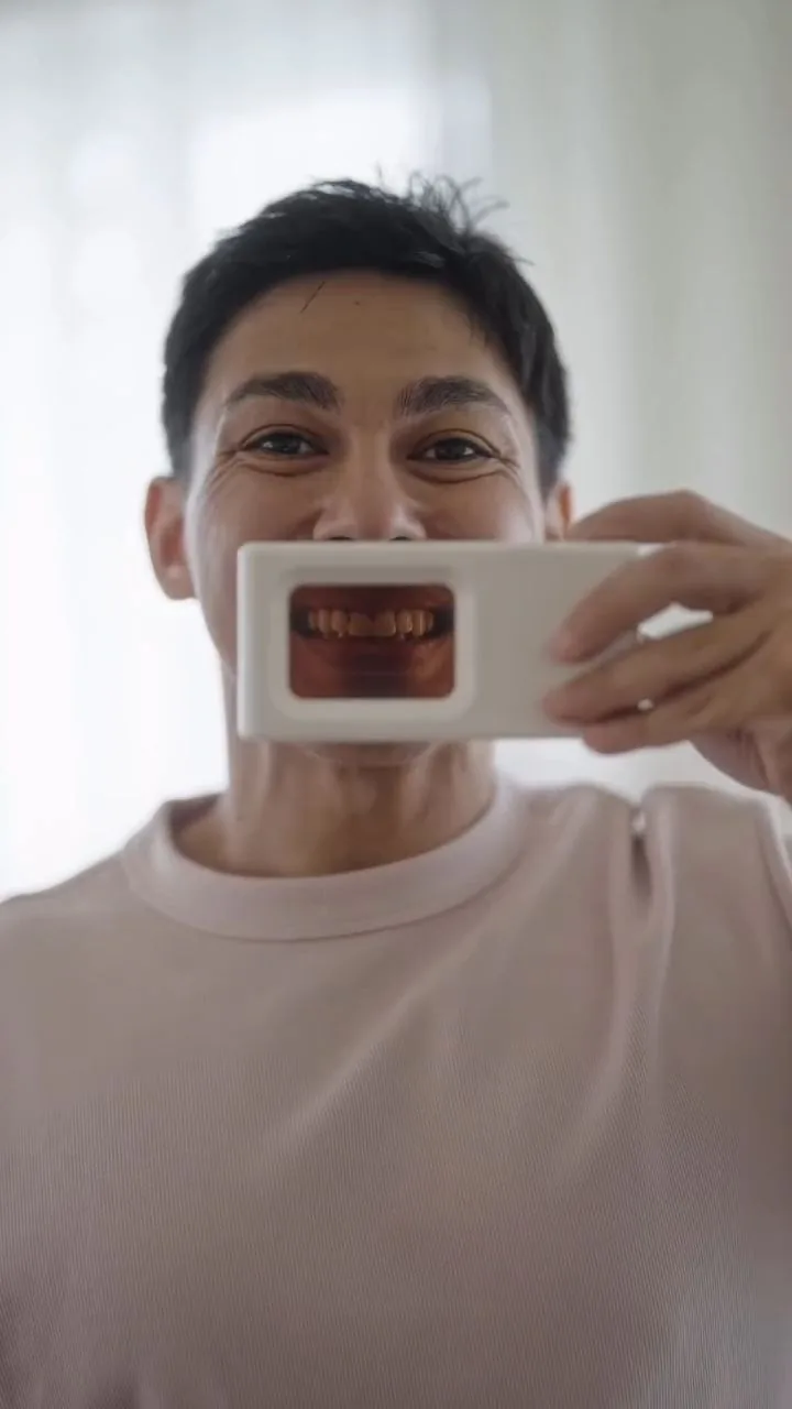 Person holding a plaque-light viewer displaying teeth, image 37