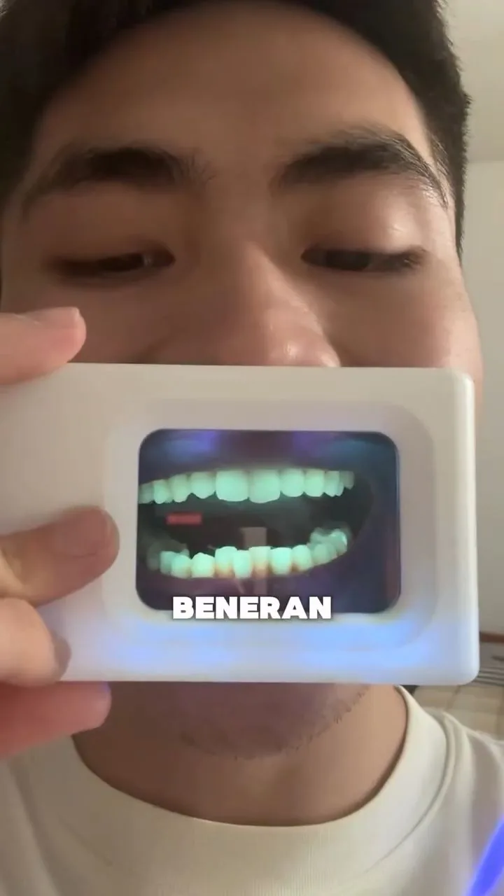 Person holding a plaque-light viewer displaying teeth, image 40