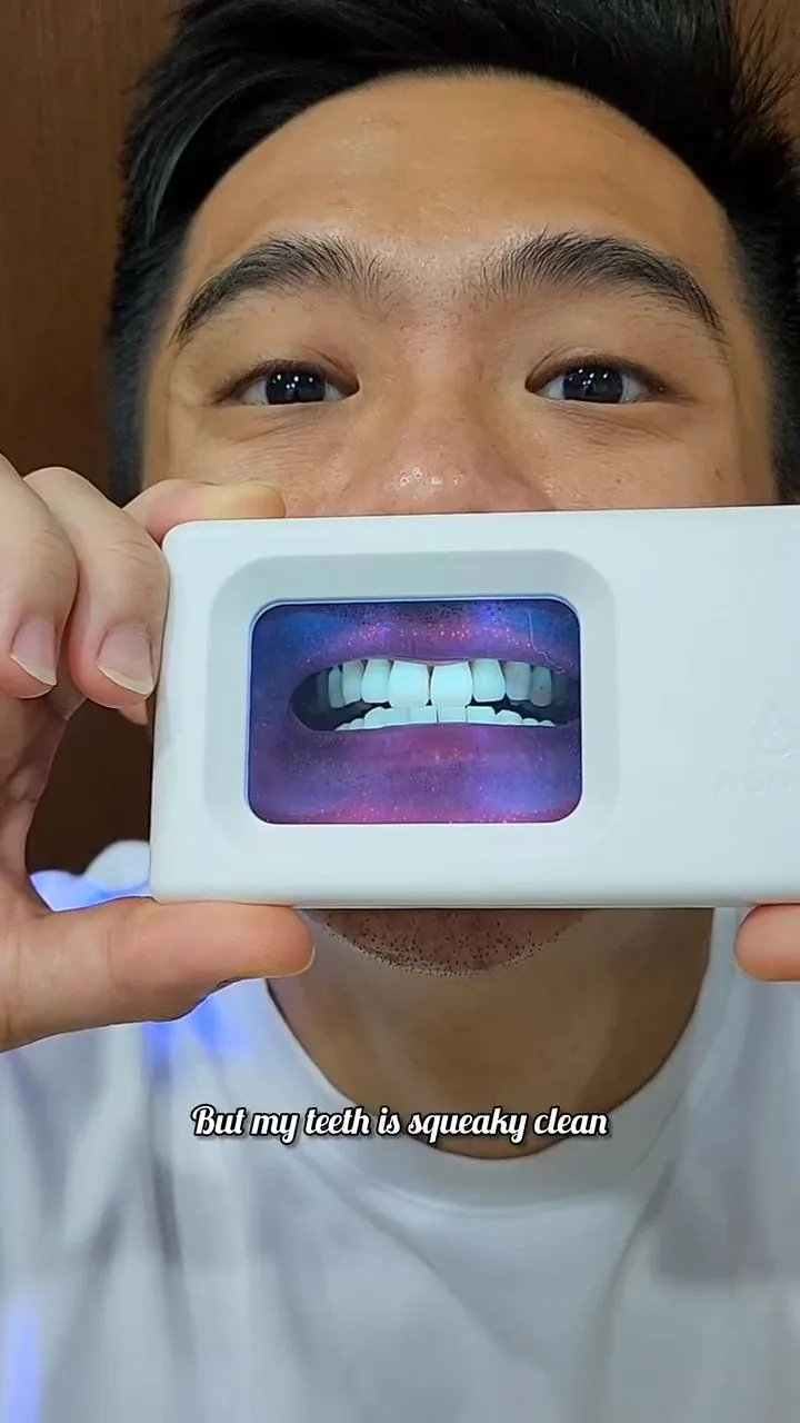 Person holding a plaque-light viewer displaying teeth, image 49